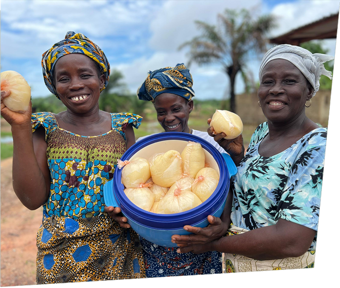 Women from a cocoa-growing community in Côte d’Ivoire holding cassava products